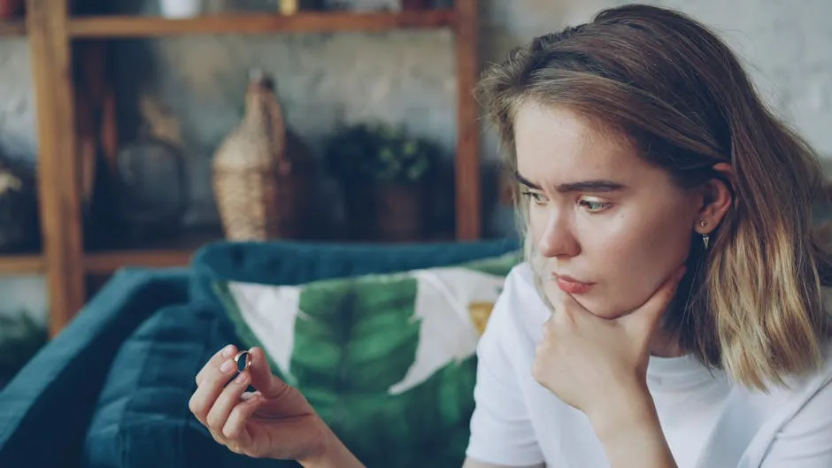 Jovem pesquisadora pensativa diante de papéis e computador, representando decisão sobre próximos passos na carreira