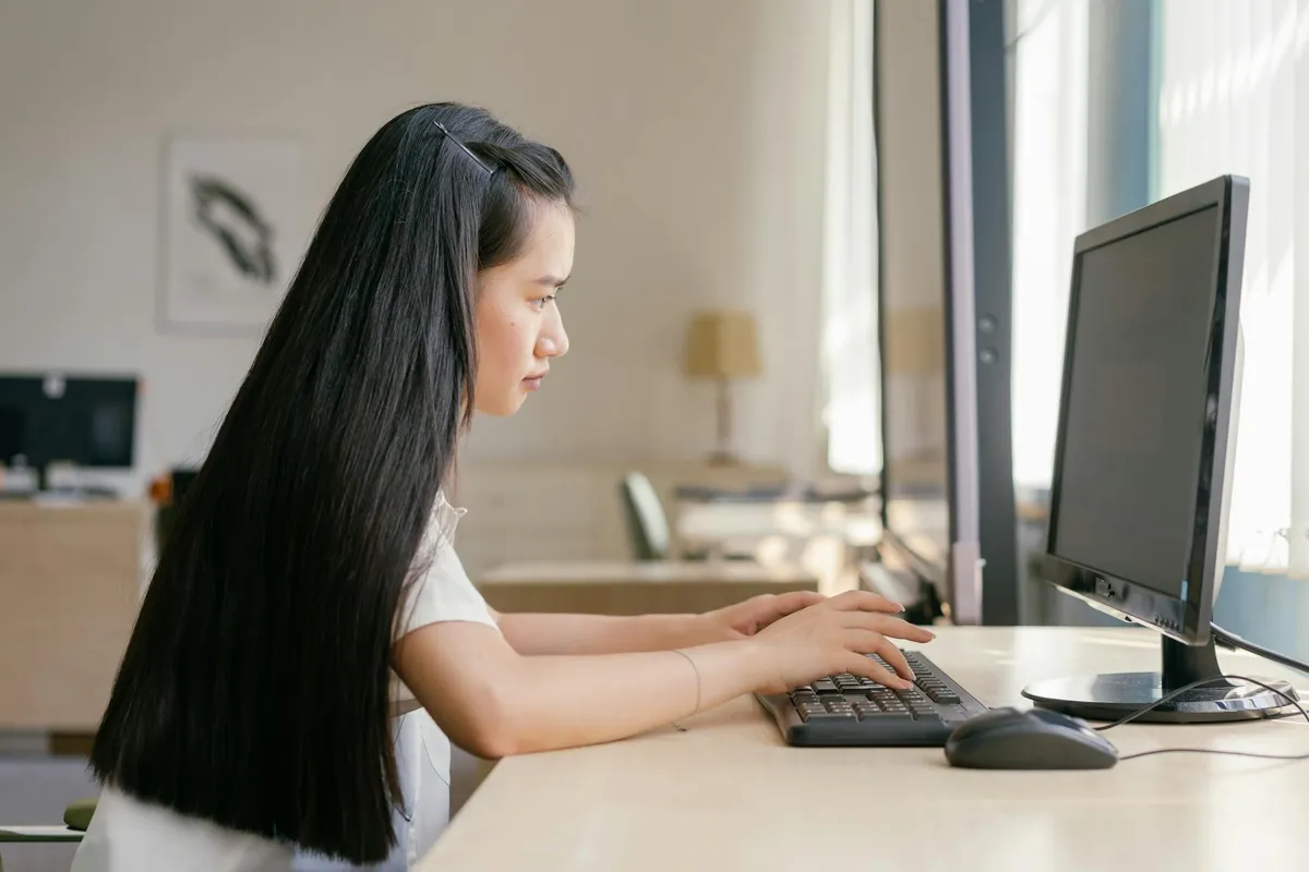 Pesquisadora usando computador para verificar referências bibliográficas