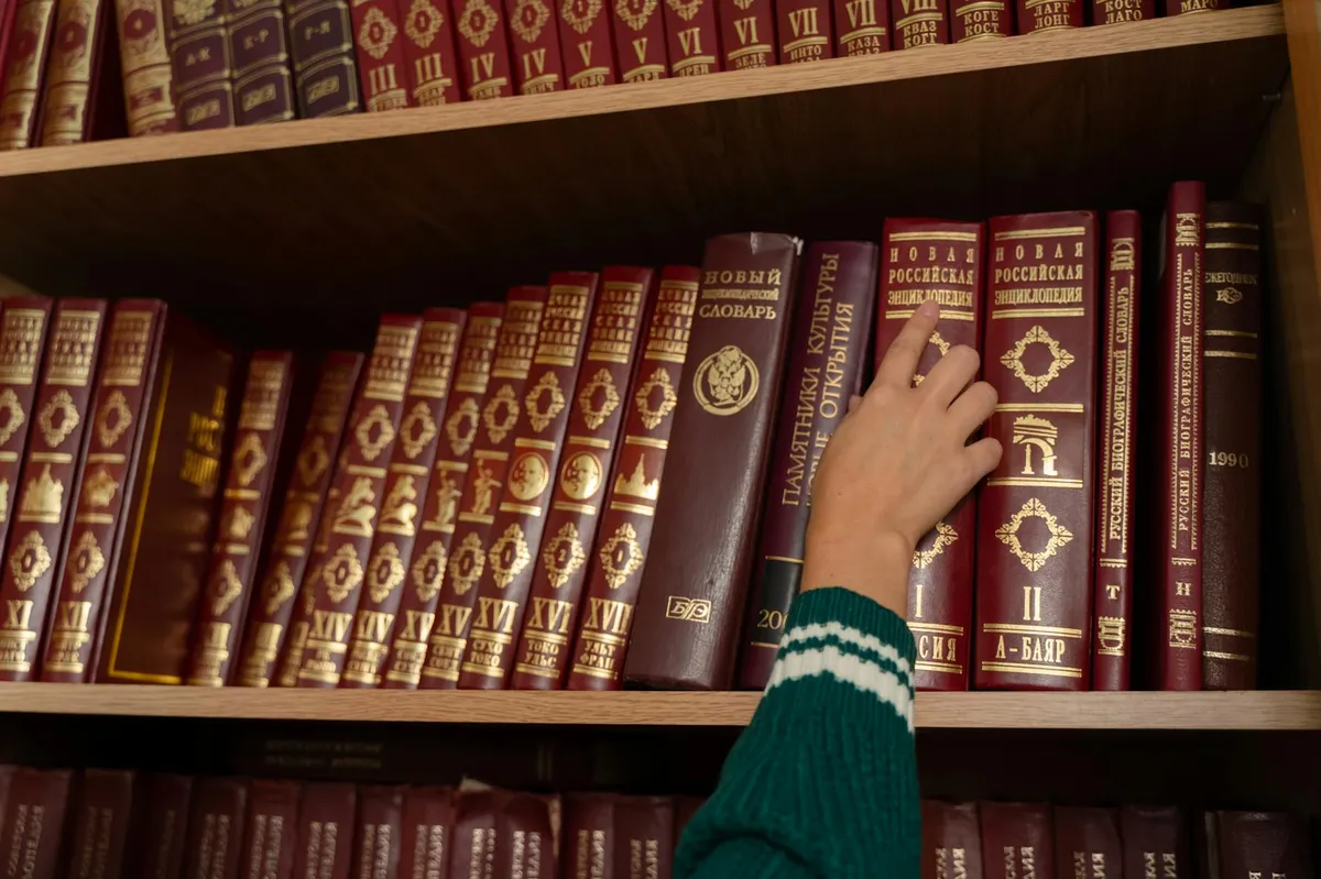 Mesa de estudos com livros abertos e caderno com anotações sobre normas acadêmicas