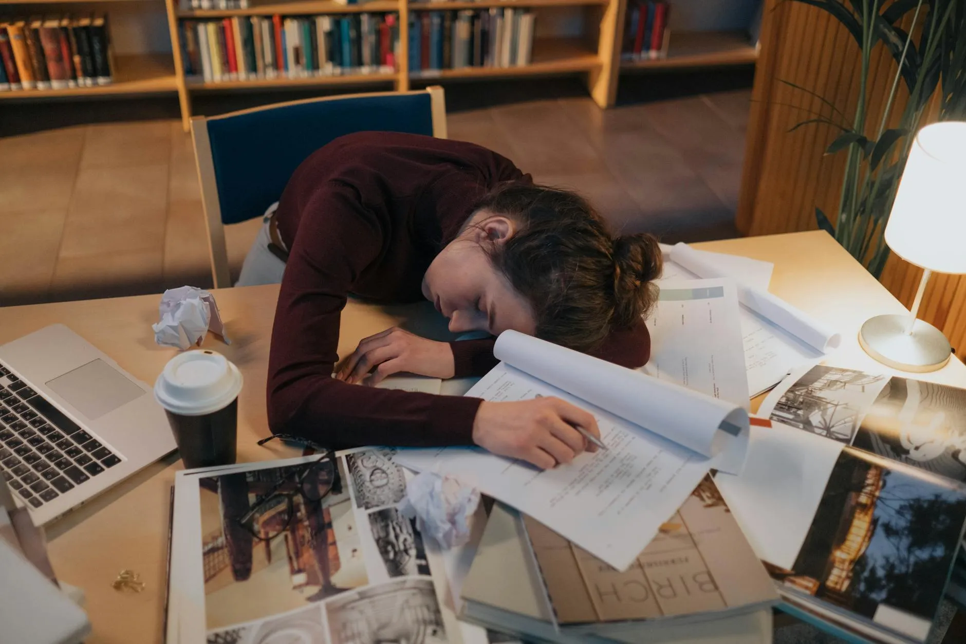 Pesquisadora alongando-se na cadeira com expressão de cansaço em frente ao computador