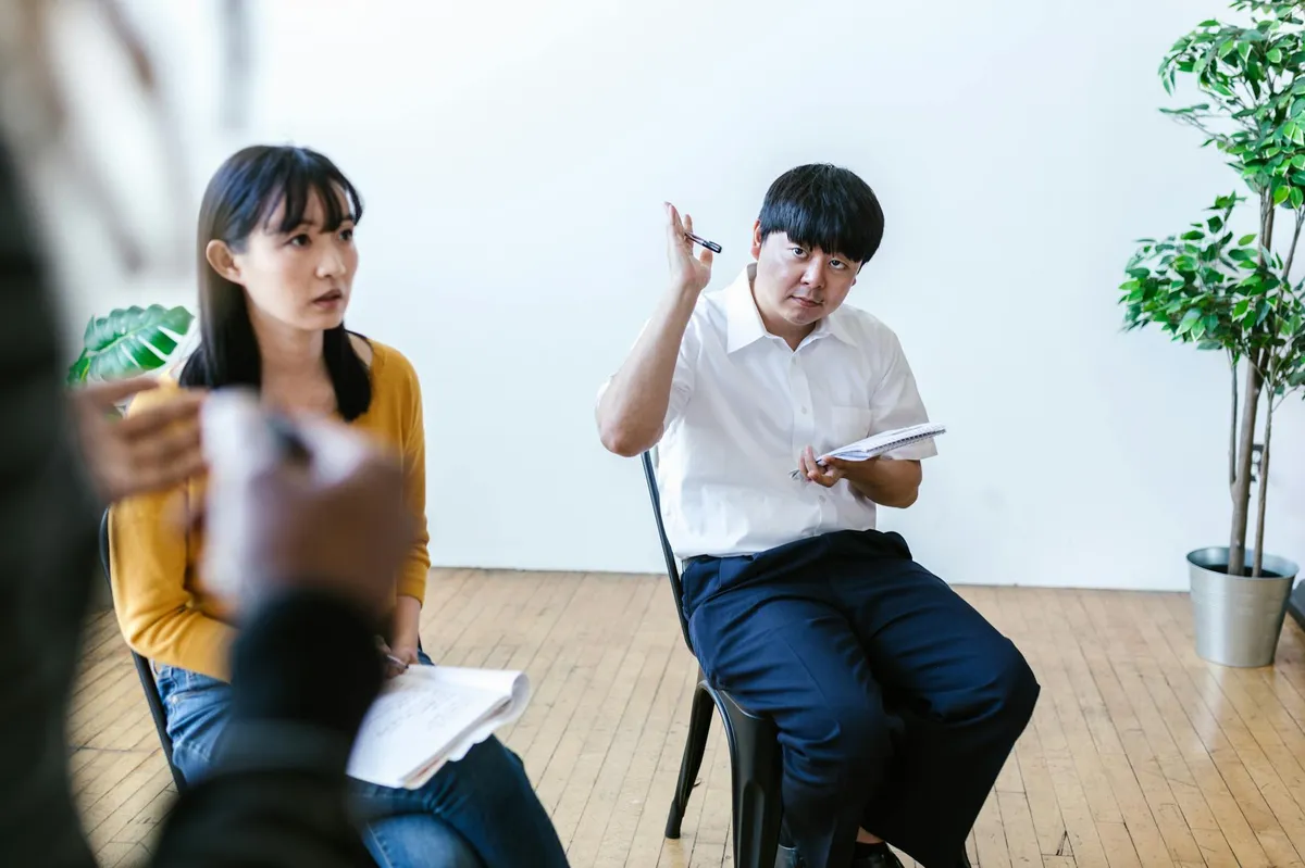 Pesquisadora analisando dados de pesquisa com participantes em sala de reunião