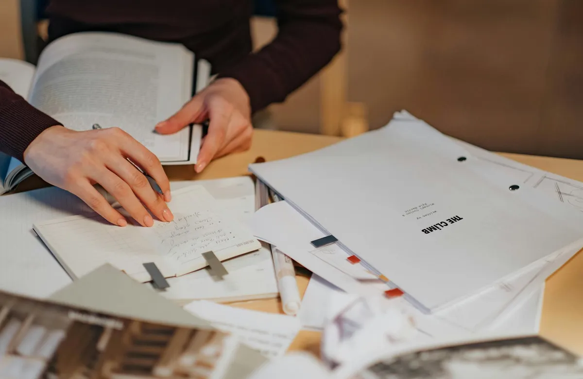 Caderno com documentos e fichamentos organizados em seções para trabalho acadêmico