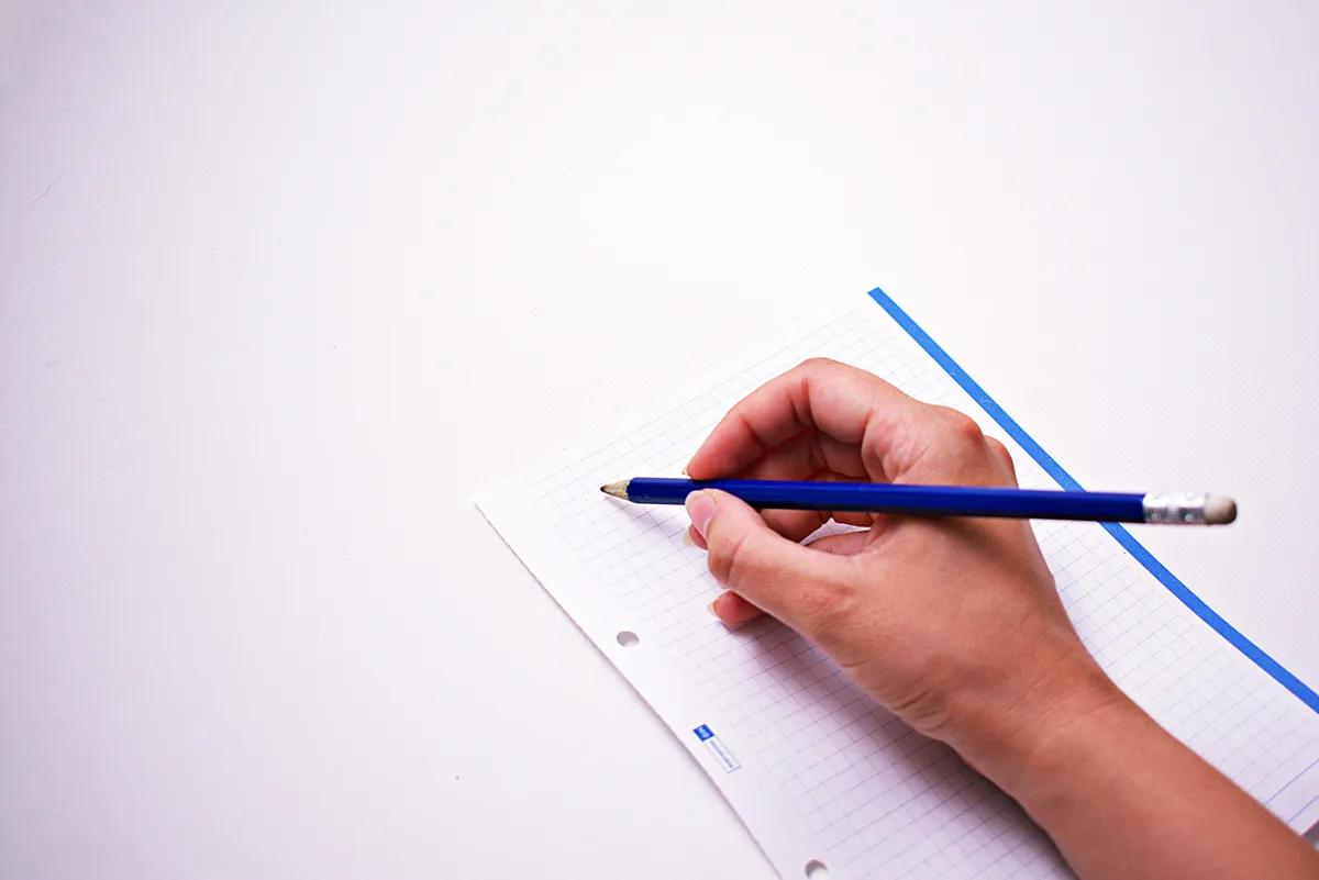 Pesquisadora revisando manuscrito de artigo científico com caneta e marcações