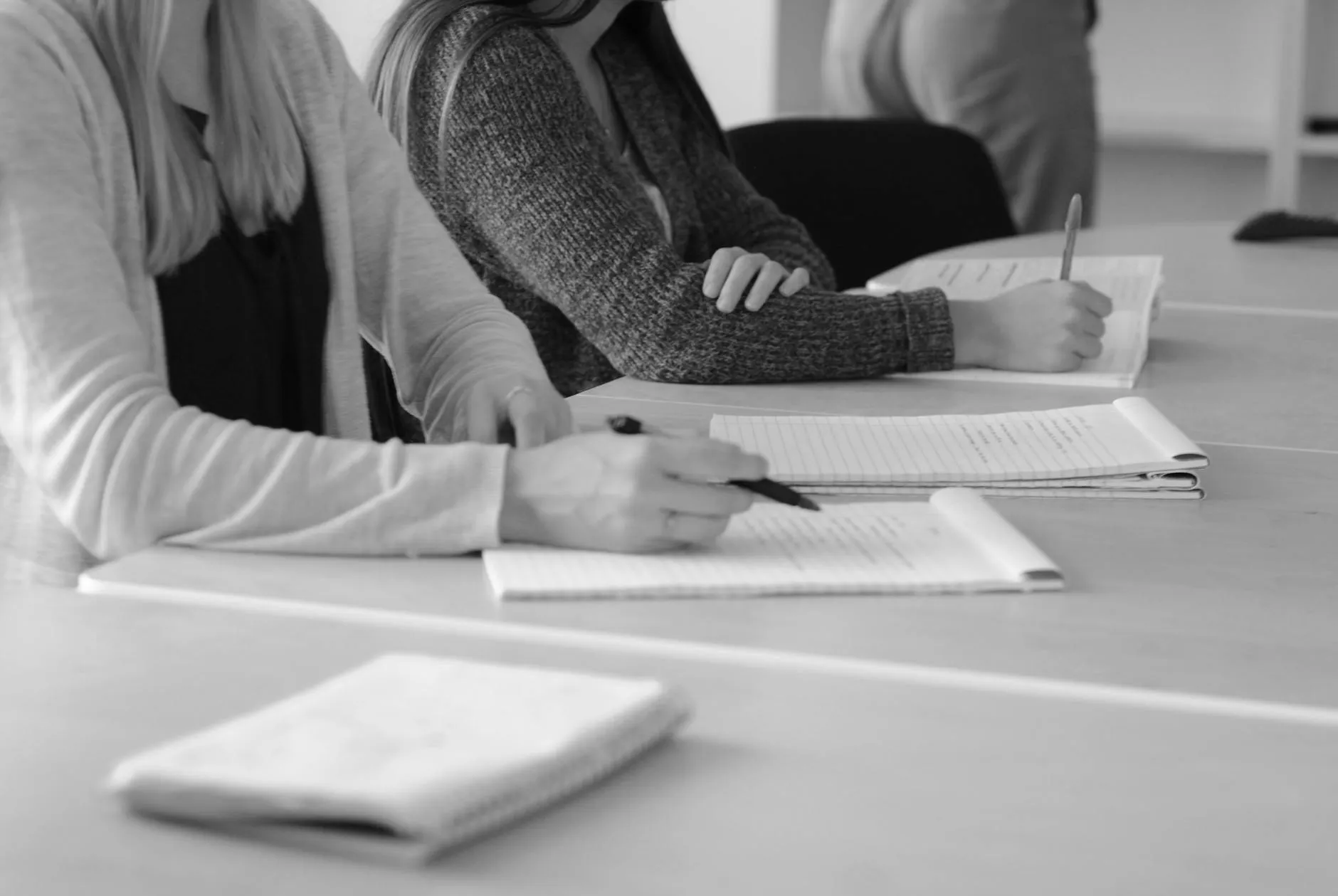 Caderno aberto com anotações de reunião em mesa de trabalho acadêmico