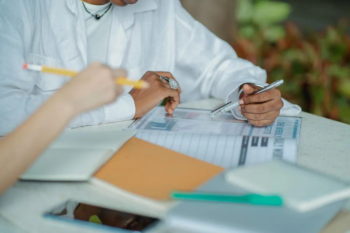 Caderno aberto com anotações de pesquisa e marcações coloridas em ambiente acadêmico