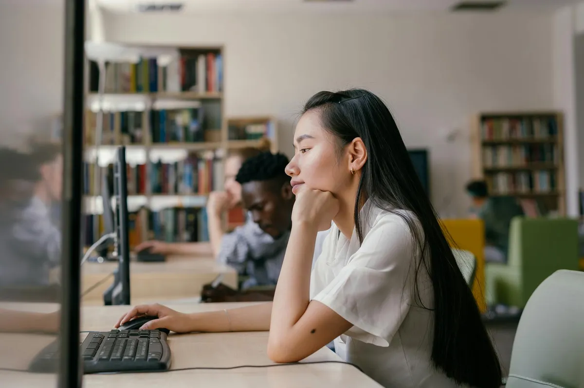 Pesquisadora estudando com documentos e computador sobre a mesa