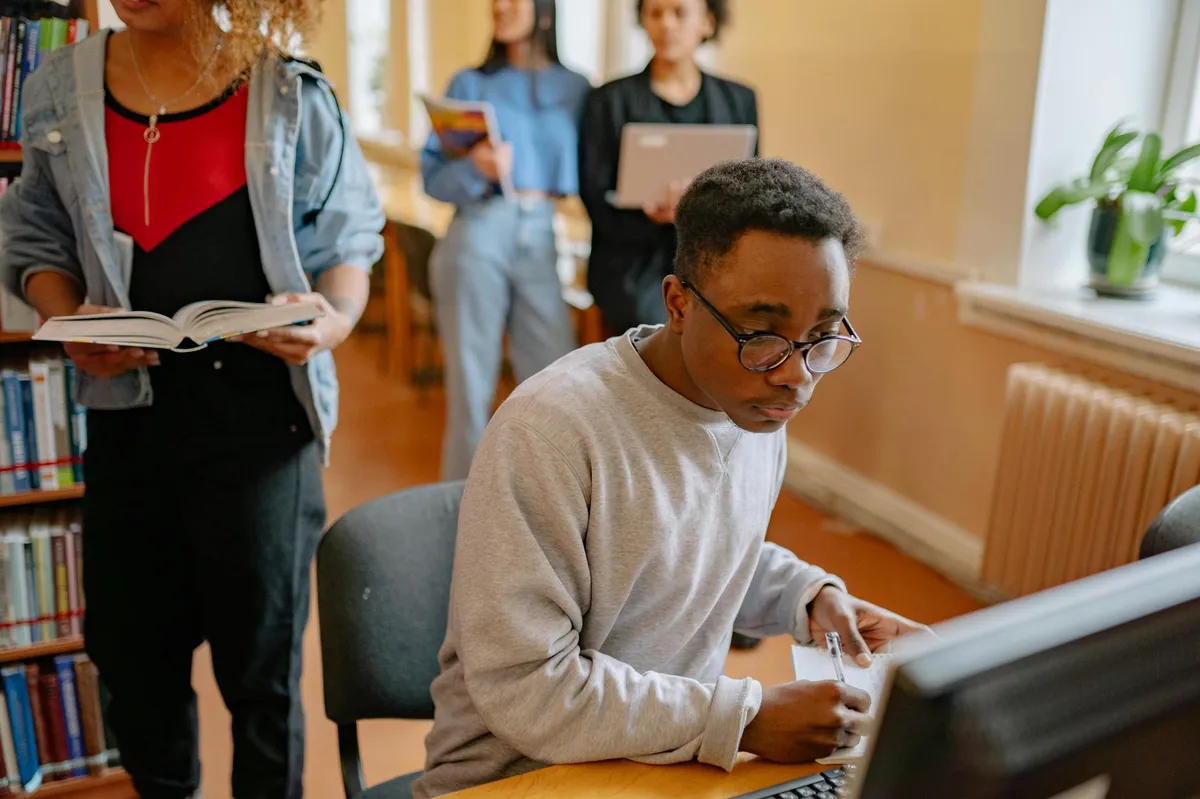 Estudante de pós-graduação trabalhando em computador em ambiente universitário
