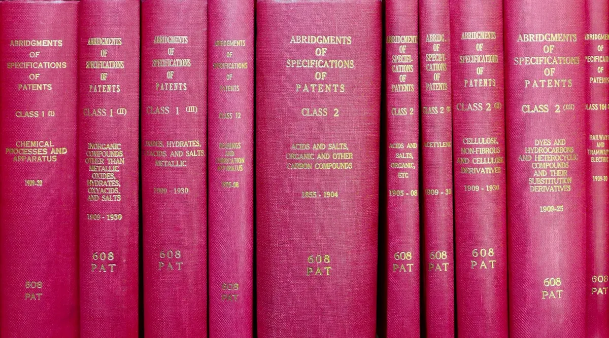 Livros jurídicos empilhados em mesa de biblioteca com iluminação de estudos