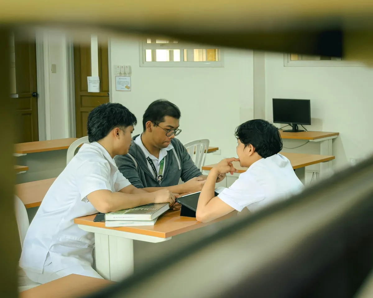 Pesquisadores colaborando em torno de mesa com documentos e computador em ambiente universitário