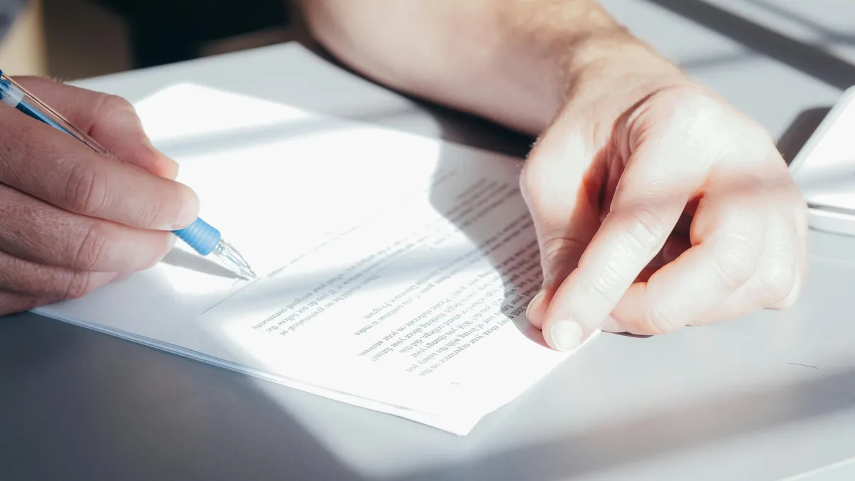 Pesquisadora lendo documento de aprovação de comitê de ética em mesa de trabalho