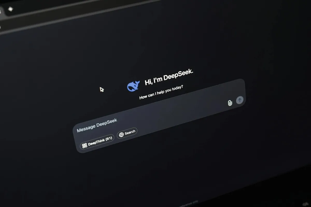 Tela de computador com interface de chat de inteligência artificial e caderno com anotações ao lado