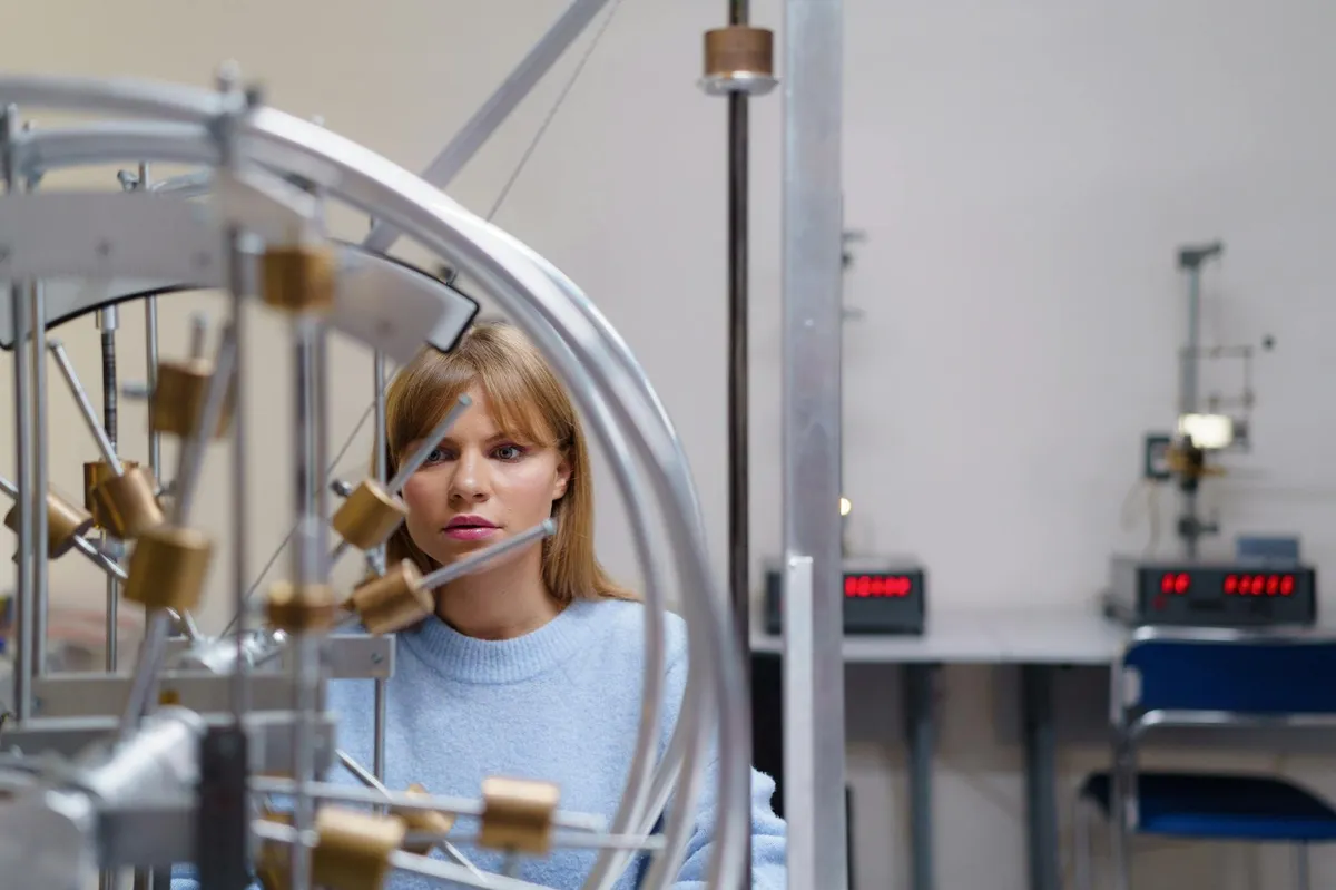 Estudante de engenharia trabalhando em laboratório com equipamentos e computadores