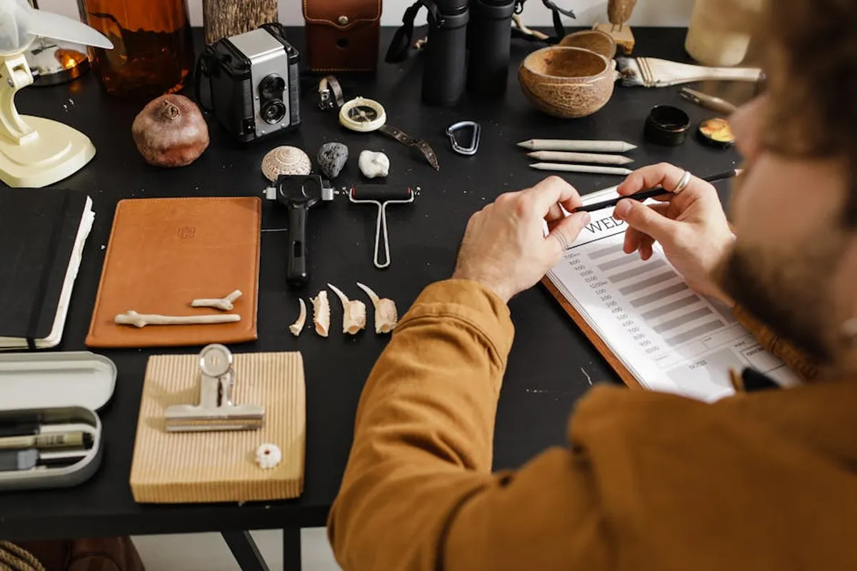 Pessoa em frente ao computador com anotações em papel na mesa