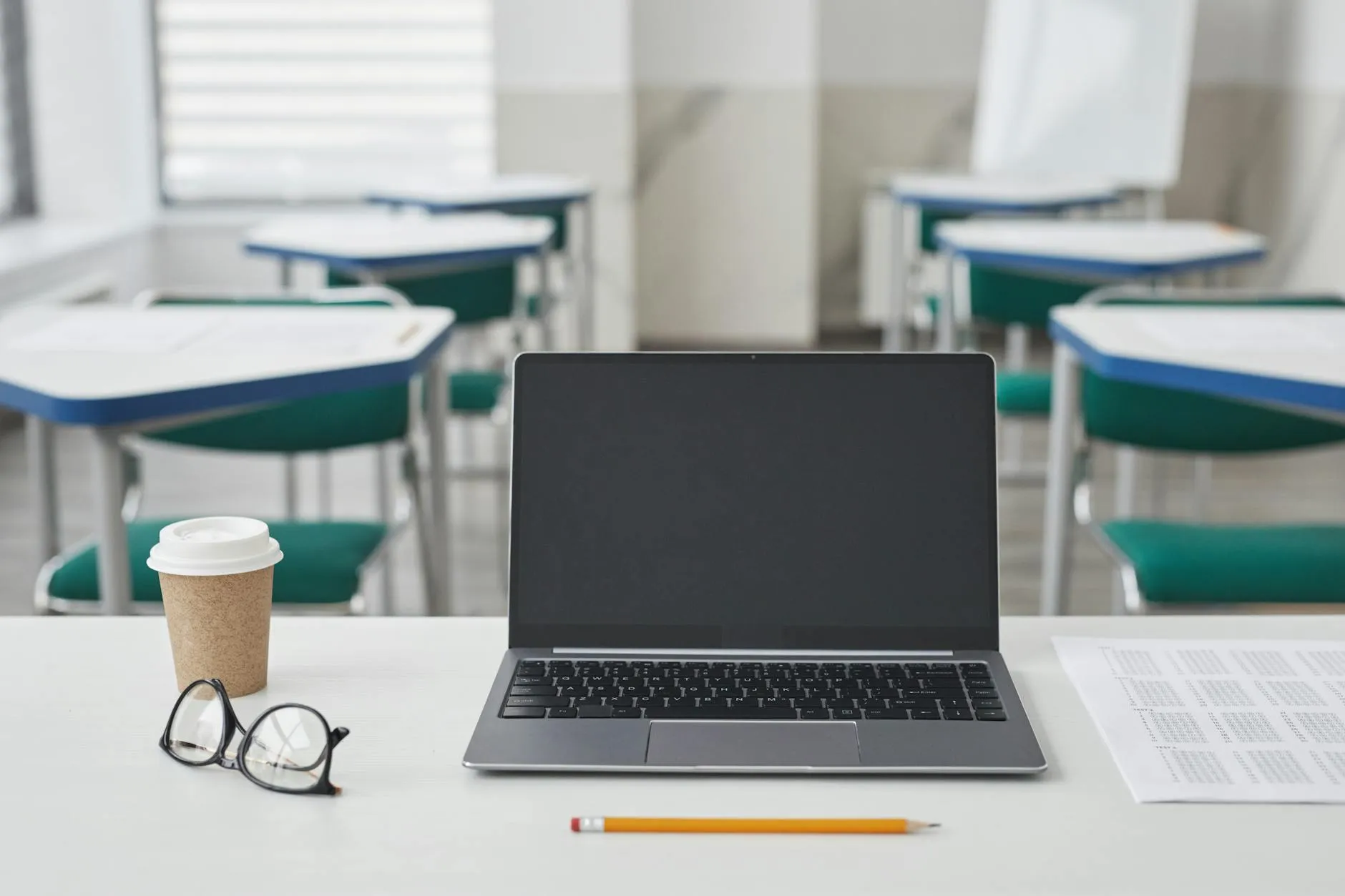 Pessoa escrevendo artigo científico em laptop com anotações ao lado