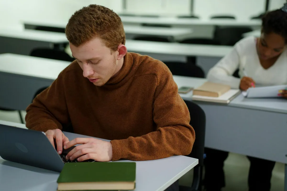 Estudante formatando trabalho acadêmico no computador com documento aberto