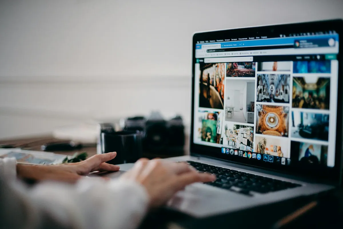 Pessoa em frente a computador pesquisando imagens para trabalho acadêmico