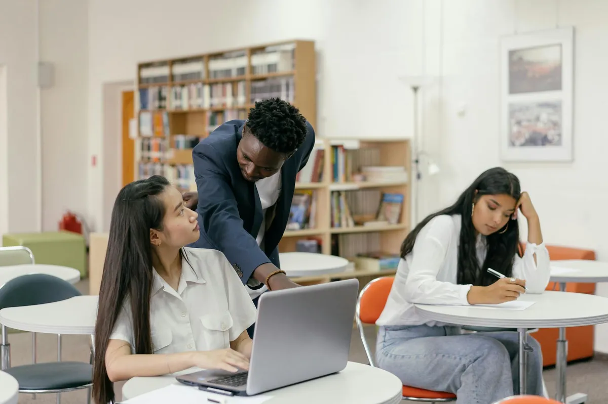 Professora e estudante em conversa séria em sala de reunião universitária
