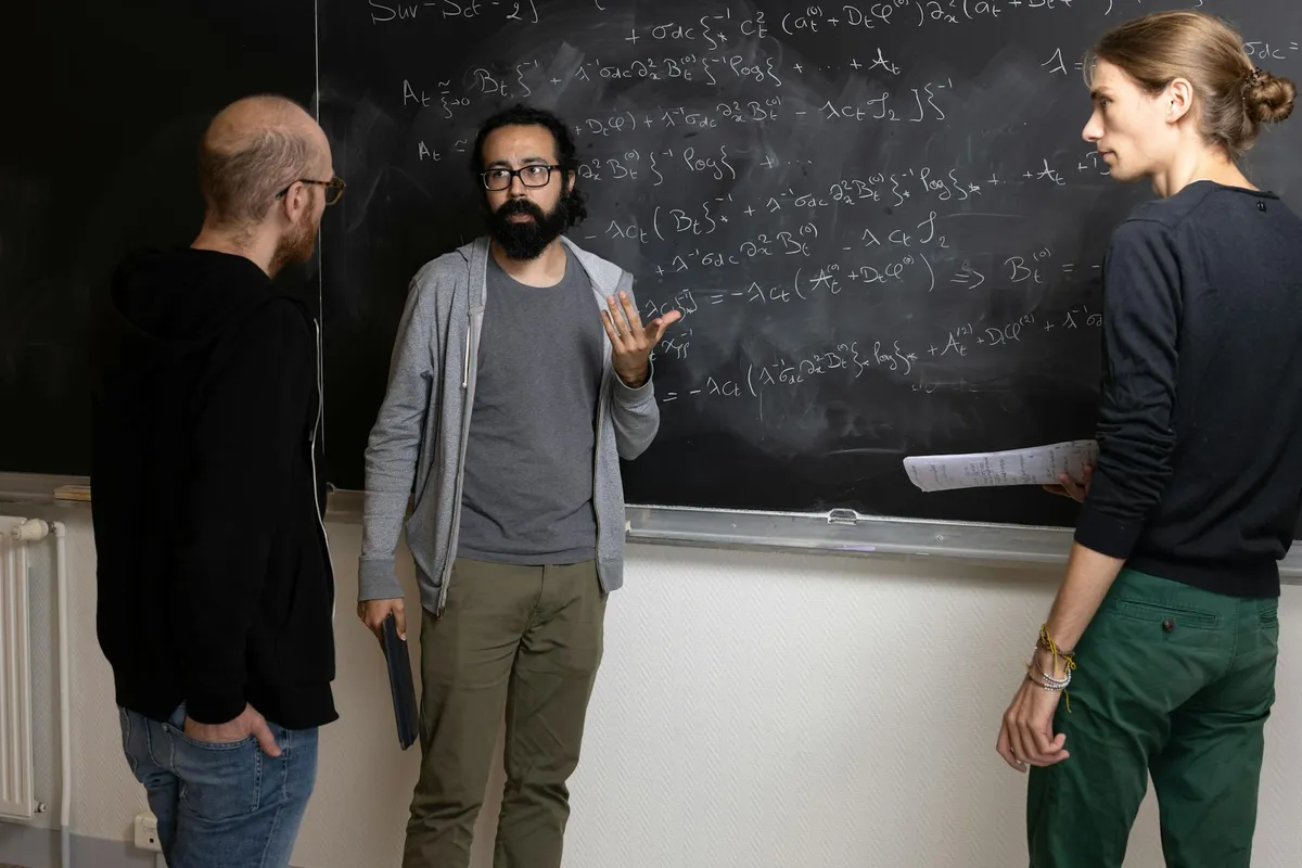Professora em uma mesa de reunião acadêmica conversando com um colega