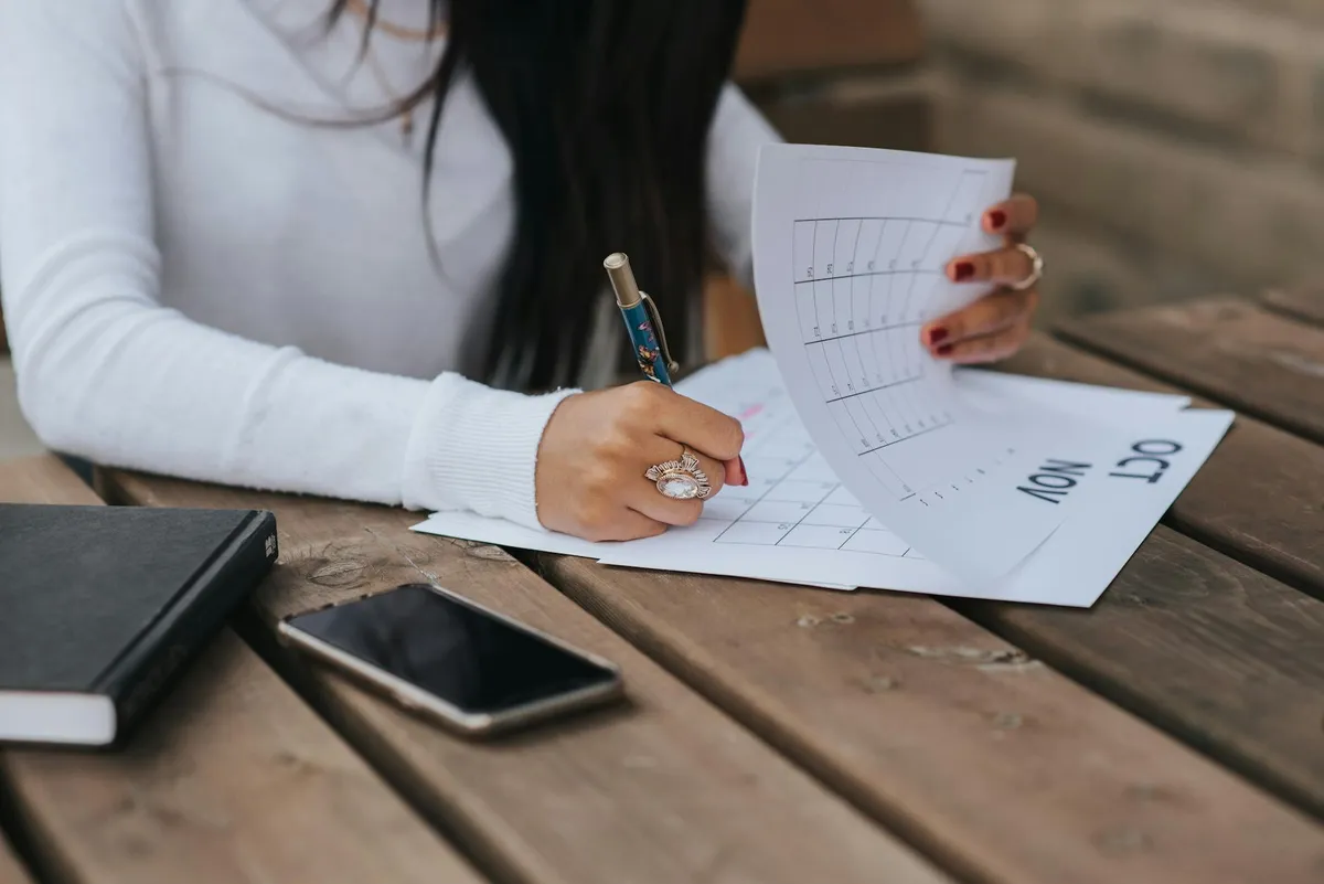 Pesquisadora organizando cronograma acadêmico em caderno e computador