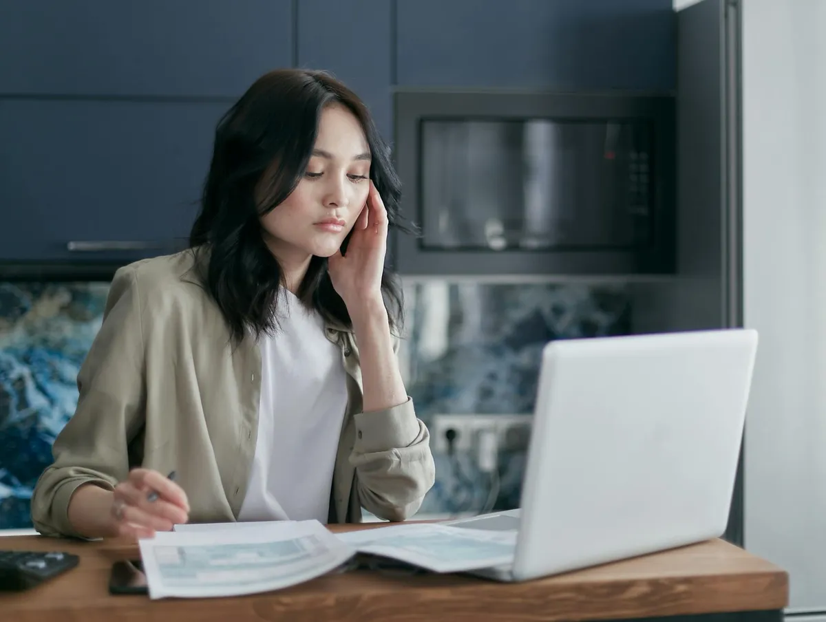 Profissional estudando com documentos e notebook em mesa de trabalho