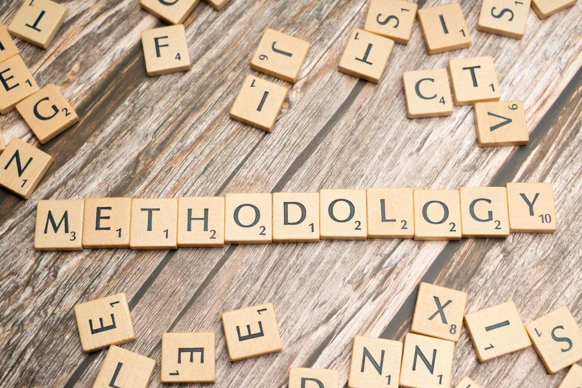 Pesquisadora analisando estrutura metodológica em lousa com diagramas de pesquisa