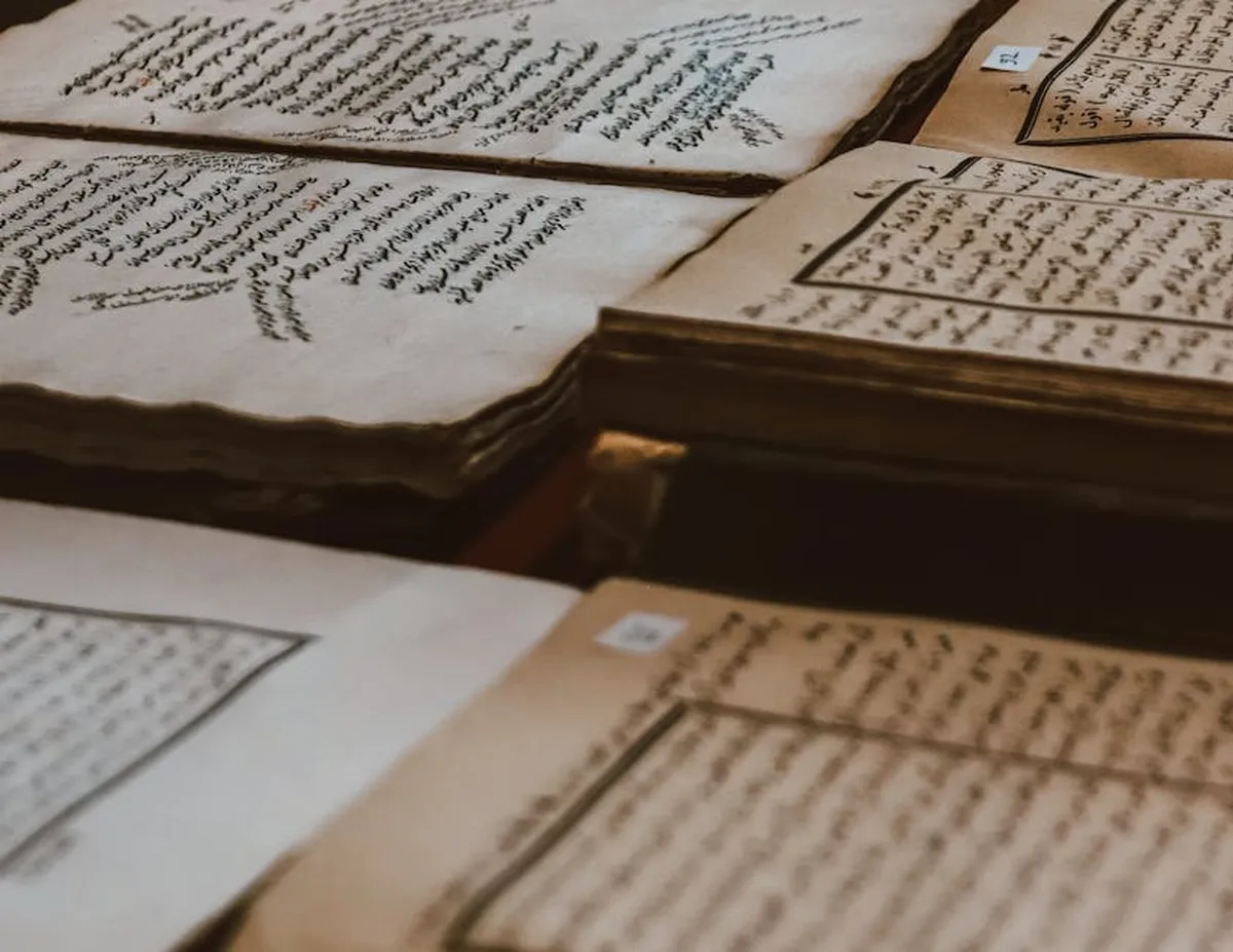 Documentos históricos antigos e livros abertos sobre mesa de pesquisador