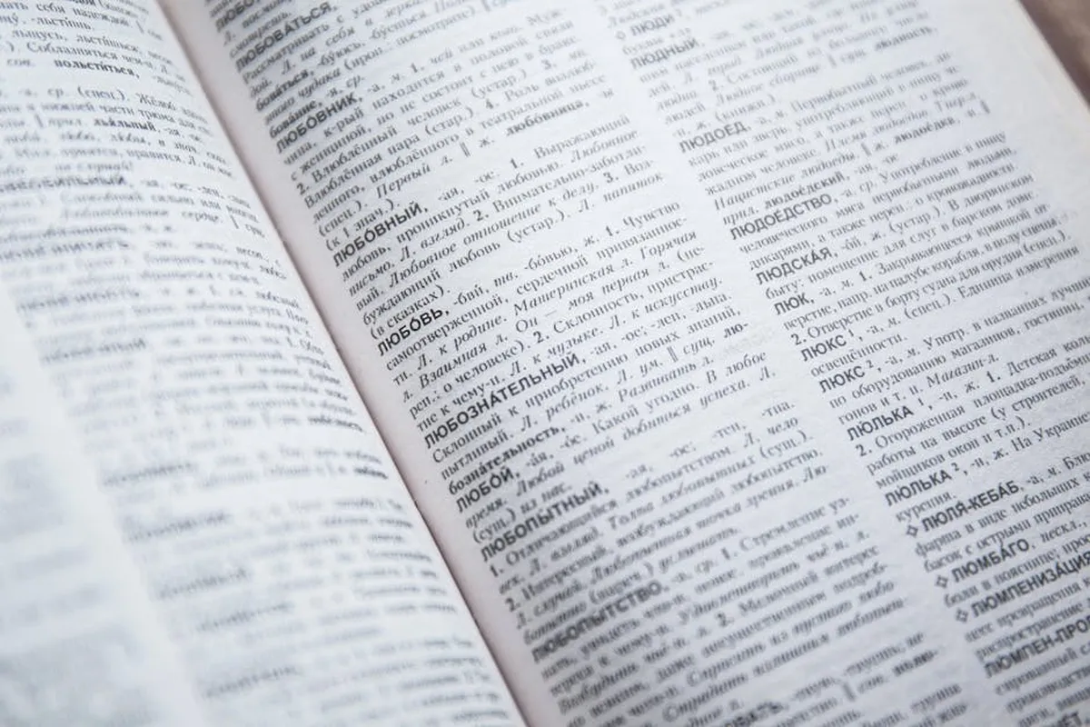 Livros abertos e textos linguísticos em mesa de pesquisadora