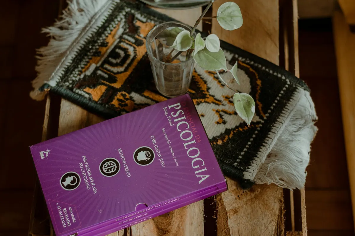 Livros de psicologia e caderno de anotações científicas sobre mesa de estudo