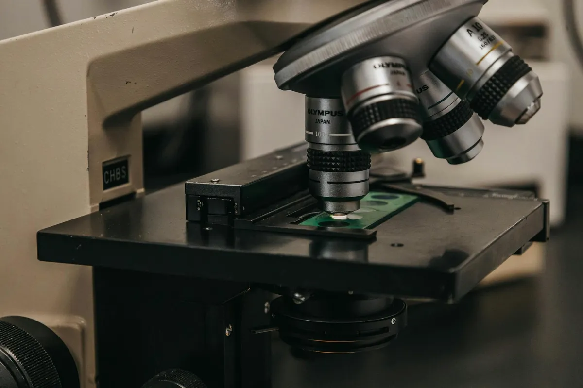 Microscopio de laboratório com amostras biológicas, representando pesquisa em ciências biológicas