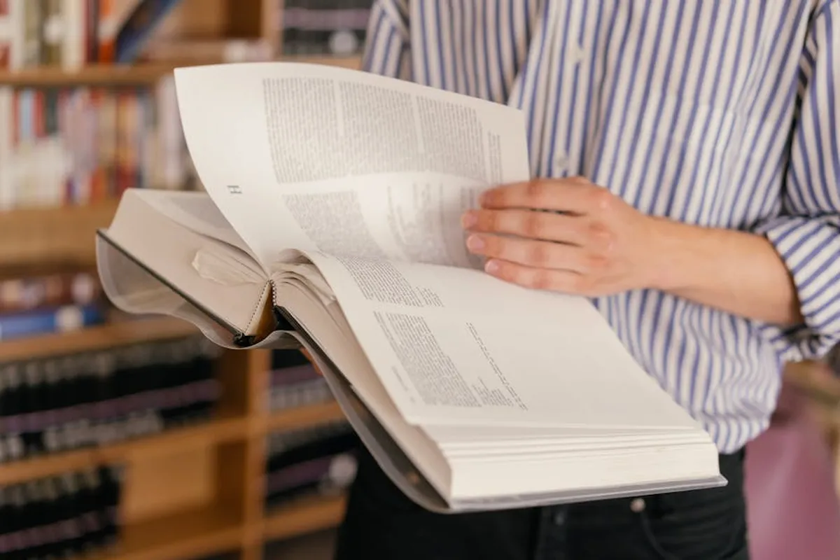 Livro aberto com frase destacada, representando uma epígrafe em trabalho acadêmico