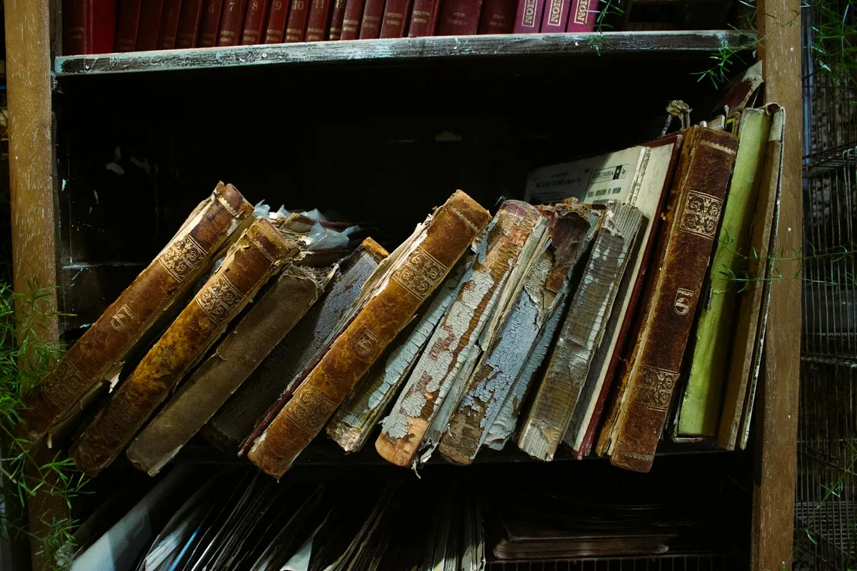 Livros antigos empilhados com páginas amareladas representando conhecimento esquecido
