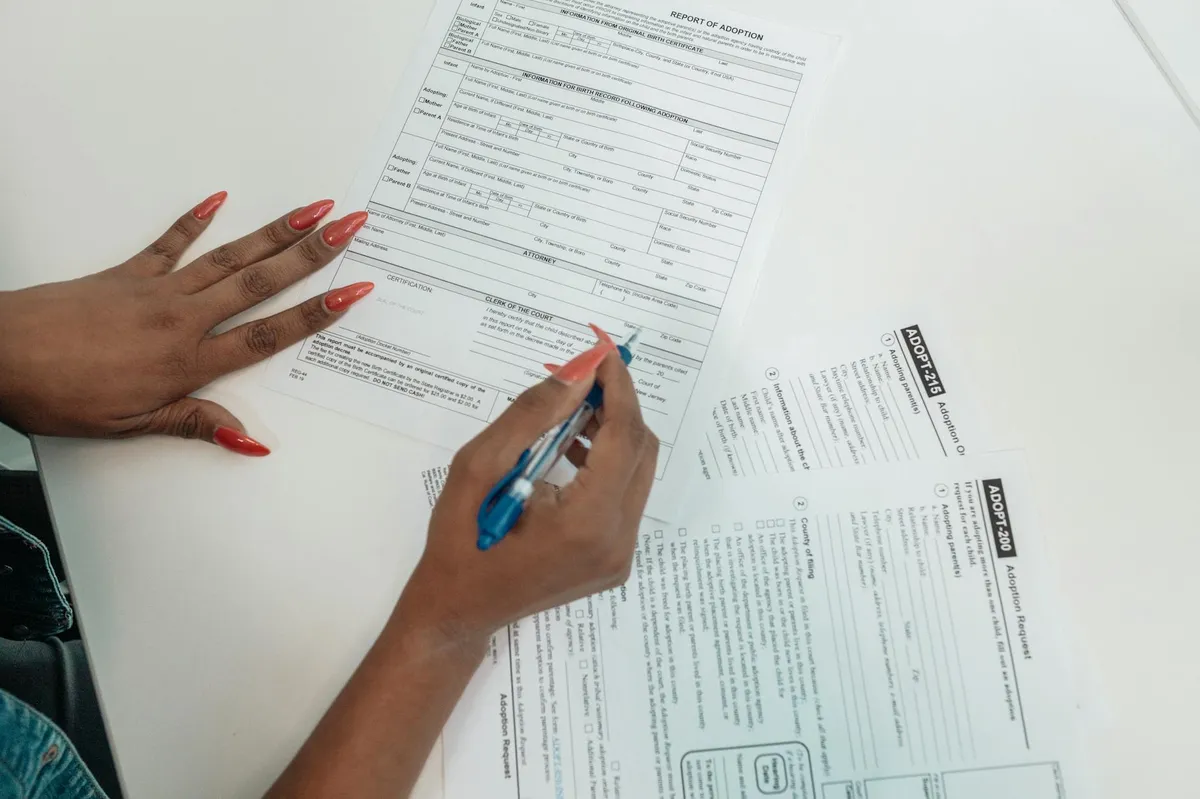 Pessoa revisando documentos em mesa de trabalho com checklist ao lado