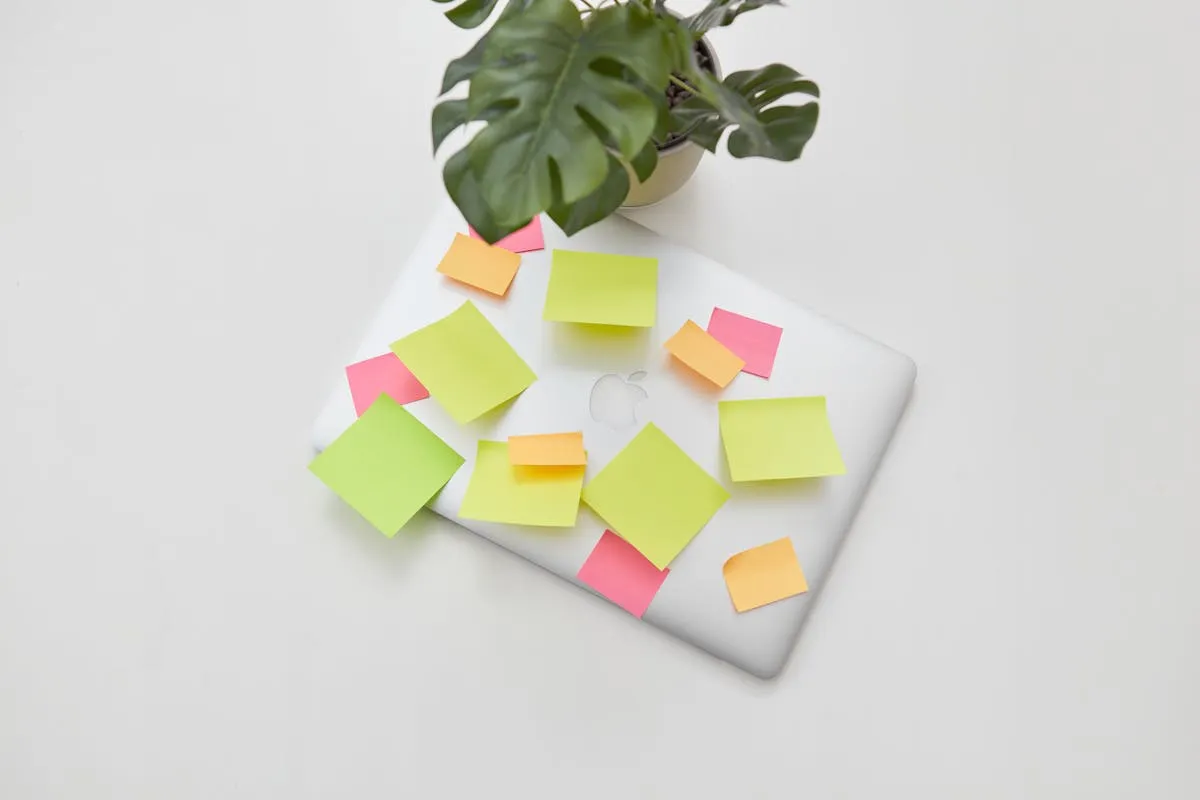 Mesa de estudo organizada com post-its coloridos, canetas e caderno aberto