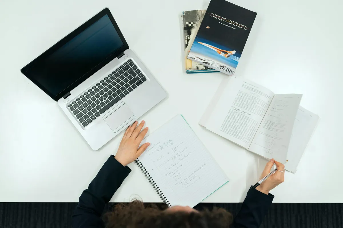 Estudante de exatas escrevendo dissertação com equações matemáticas ao fundo