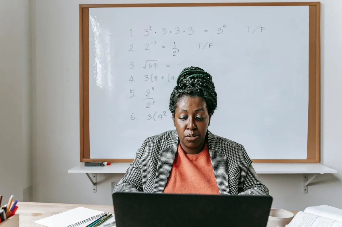 Professora em sala de aula com tablet e projetor exibindo interface de inteligência artificial