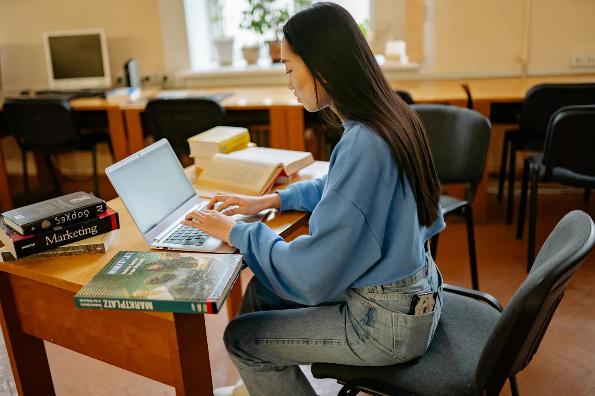 Estudante formatando trabalho acadêmico no computador usando ferramentas online gratuitas