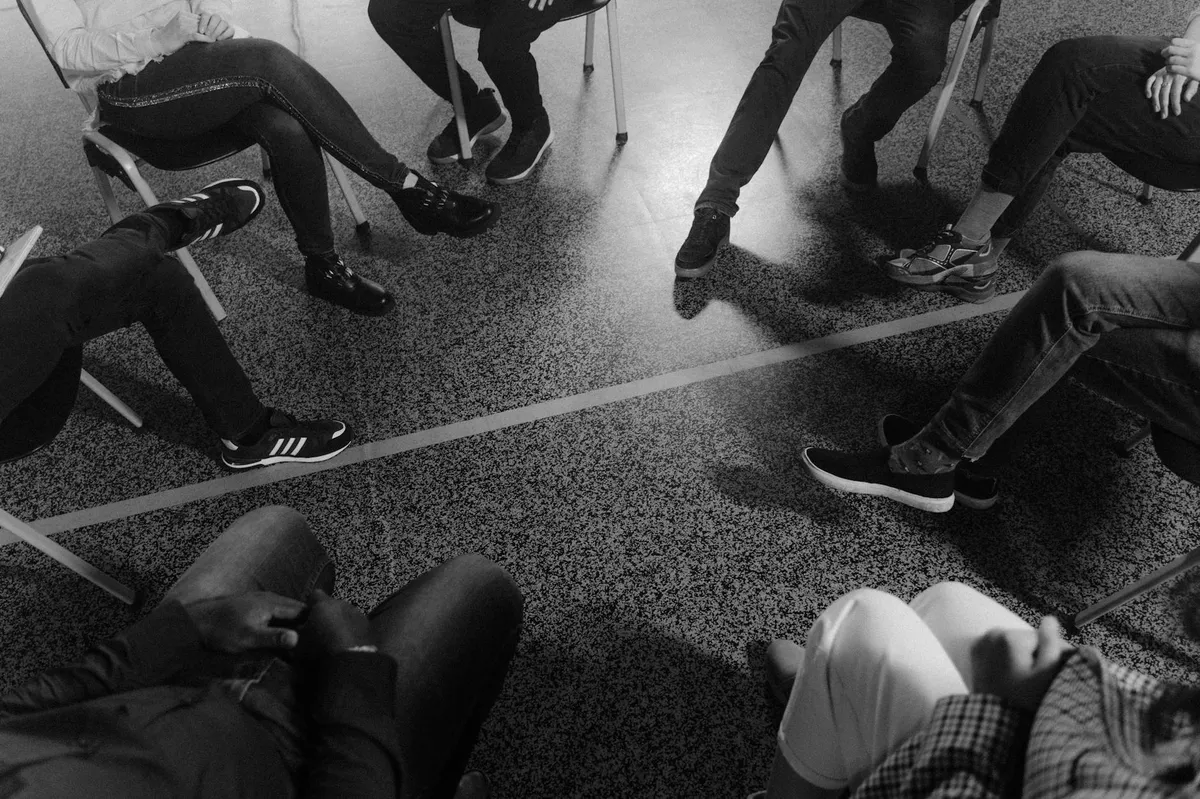 Grupo de pessoas sentadas em roda conversando durante sessão de pesquisa acadêmica