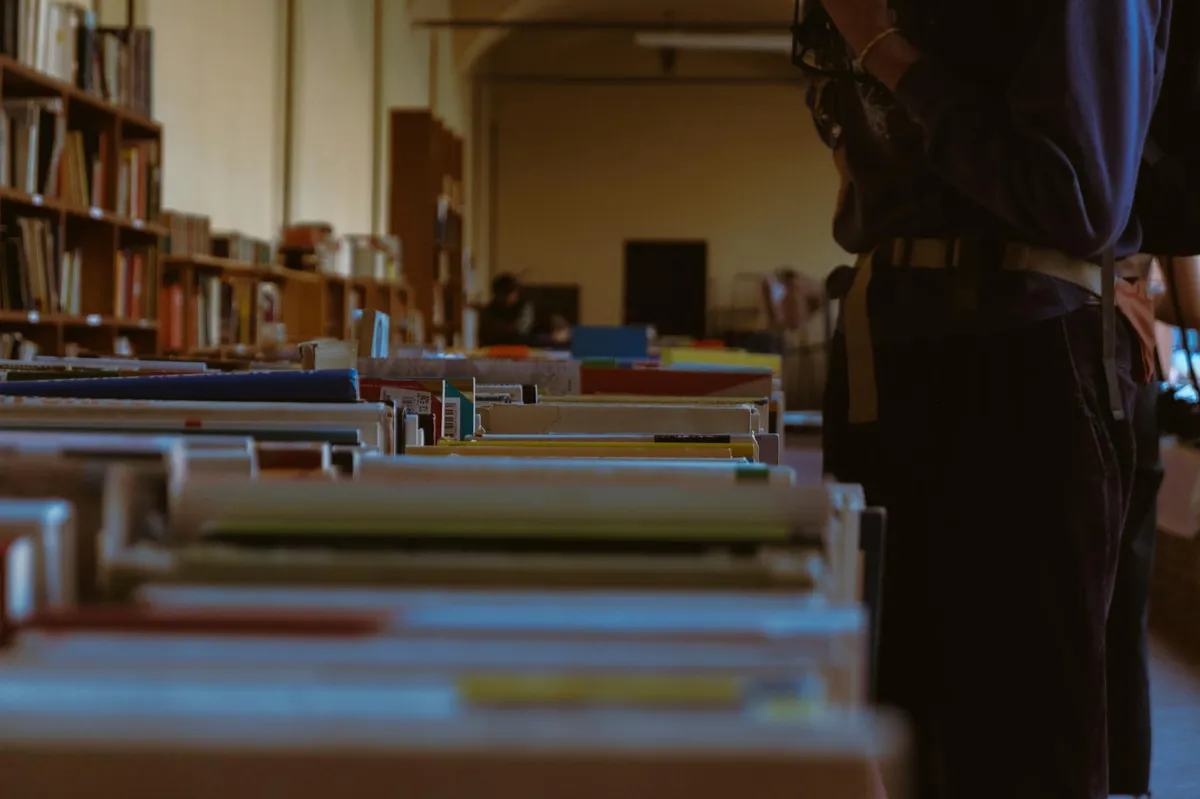 Livros de diferentes áreas do conhecimento organizados em estante universitária