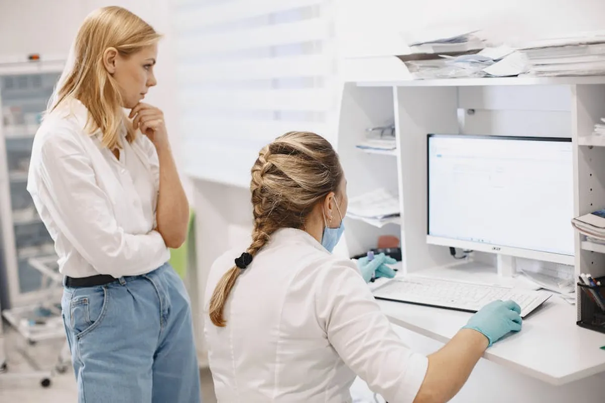 Pesquisadora analisando dados clínicos em computador em ambiente hospitalar