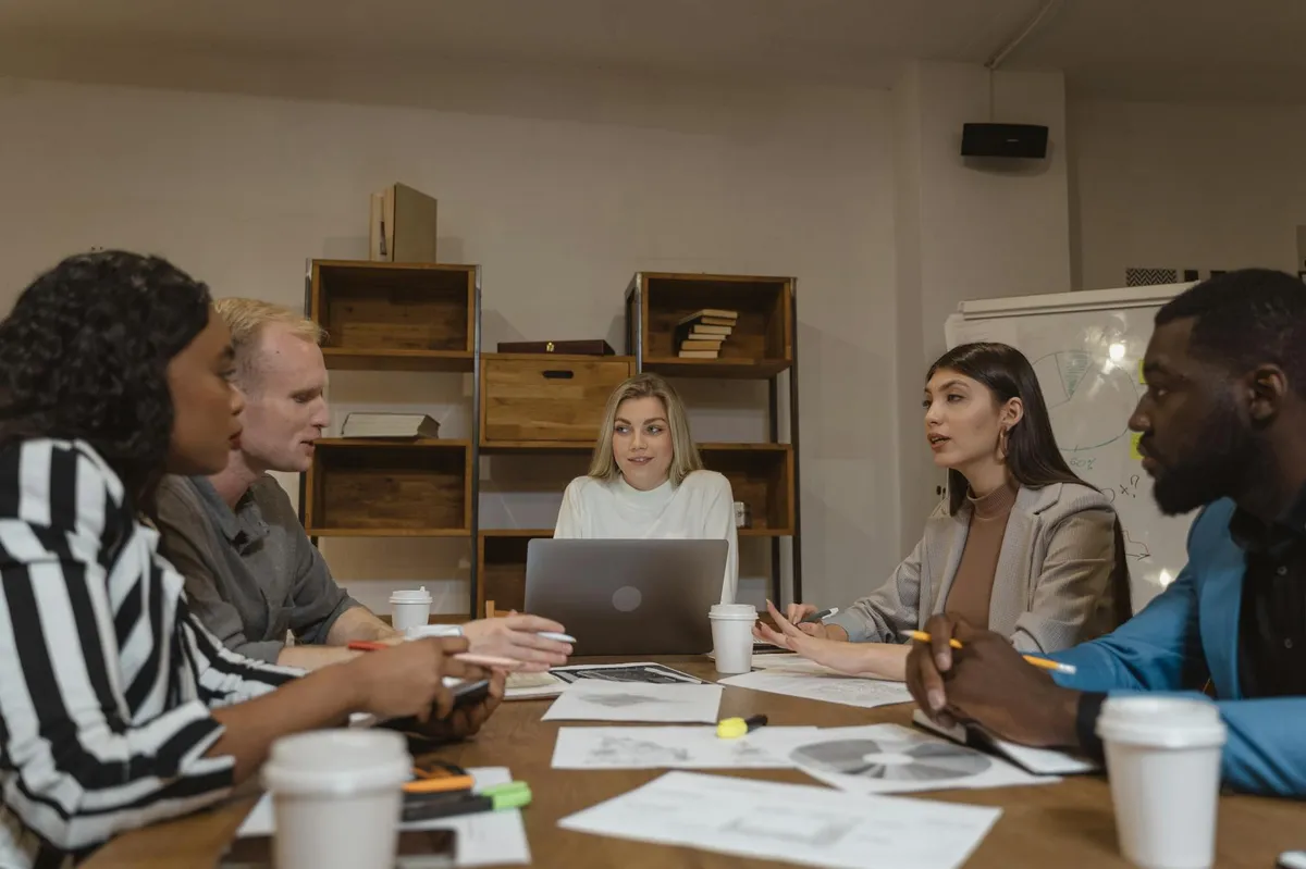 Pesquisadora em campo colaborando com grupo em círculo de discussão com anotações em flip chart