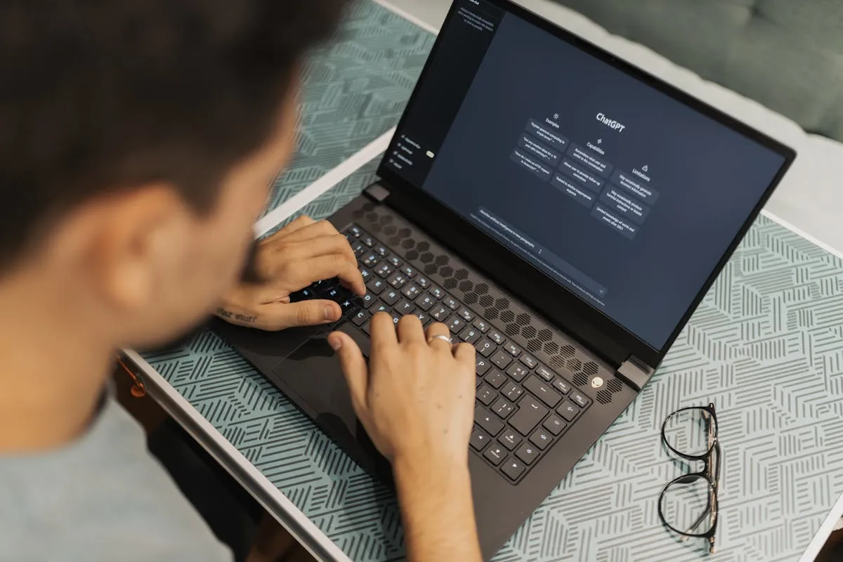 Pessoa usando computador com interface de IA para pesquisa acadêmica