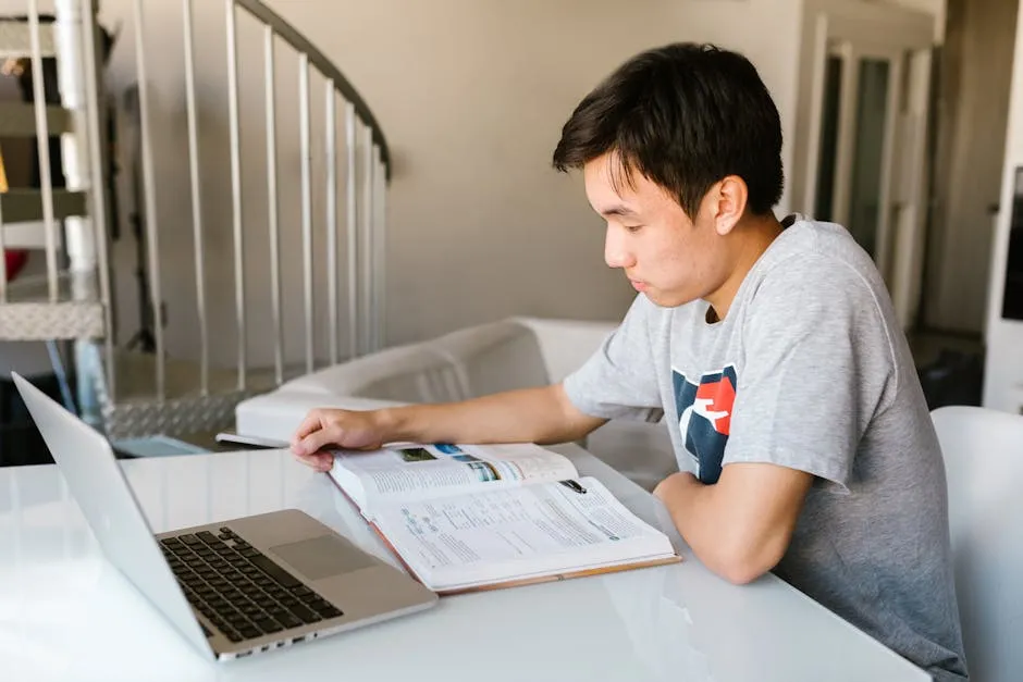 Estudante de direito com laptop aberto ao lado de livros jurídicos
