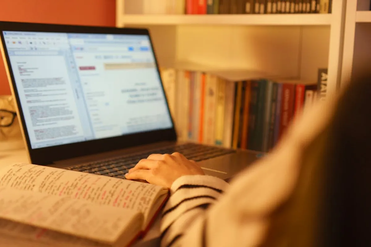 Pessoa estudando em home office com laptop, representando educação a distância no mestrado