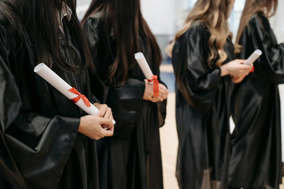 Profissional de enfermagem estudando documentos e materiais acadêmicos em biblioteca universitária