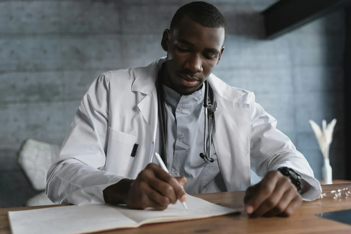 Profissional de saúde estudando documentos acadêmicos em mesa de trabalho