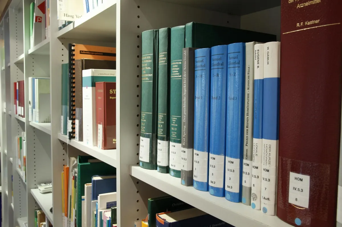 Livros acadêmicos empilhados com marcadores coloridos representando referências e citações