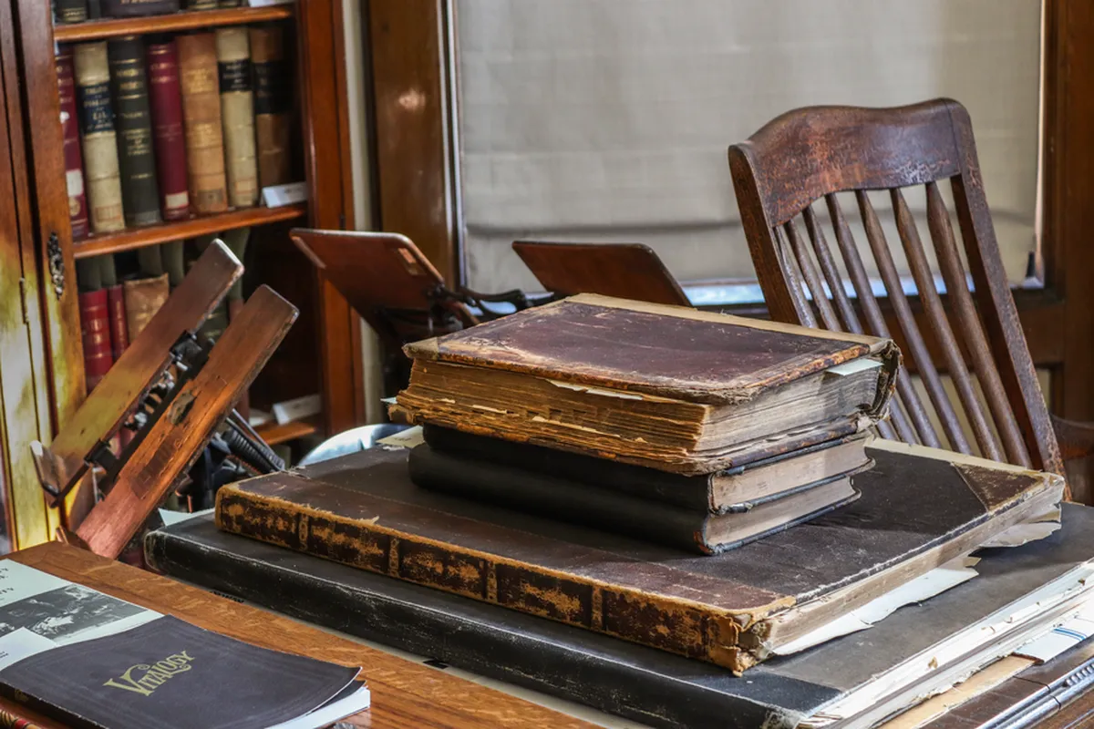 Pilha de periódicos acadêmicos sobre uma mesa em uma biblioteca