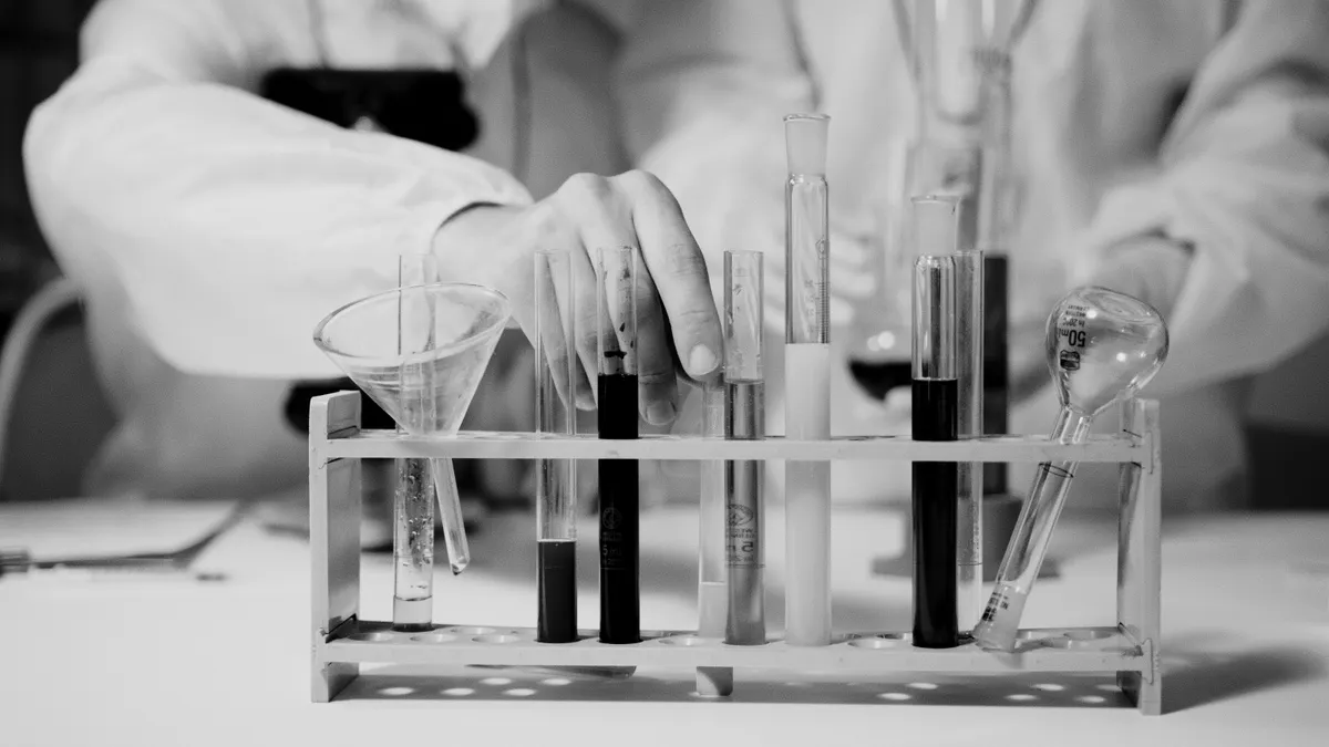 Mãos de uma criança sendo seguradas por um adulto, em ambiente hospitalar