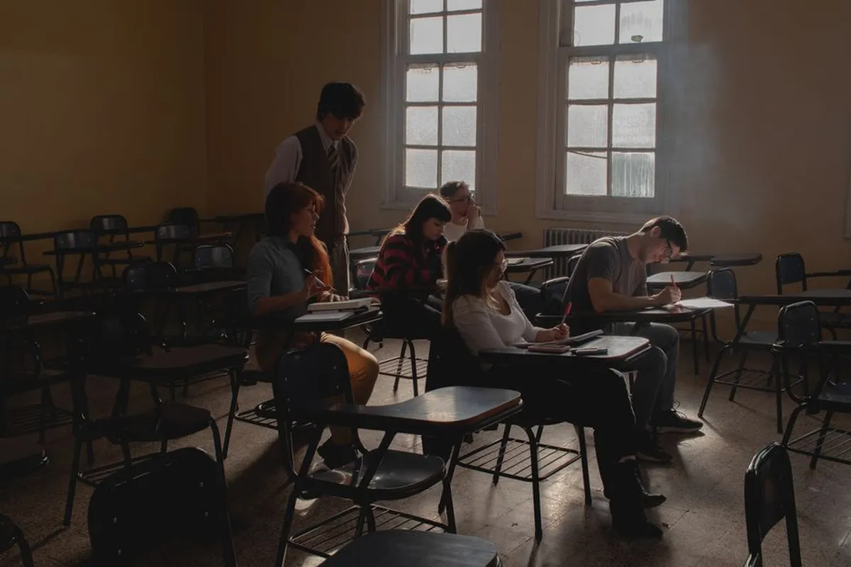 Sala de aula de Educação de Jovens e Adultos, com estudantes adultos e professora