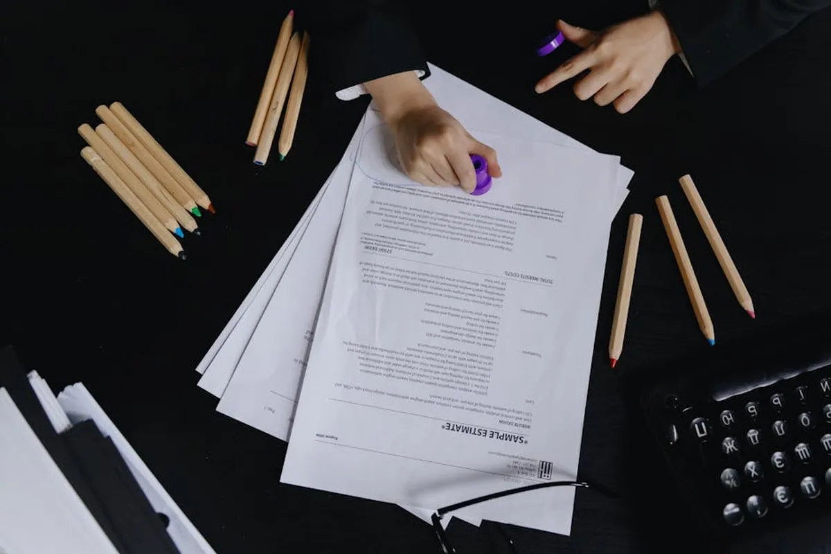 Mesa de trabalho organizada com cadernos, laptop e documentos acadêmicos formatados